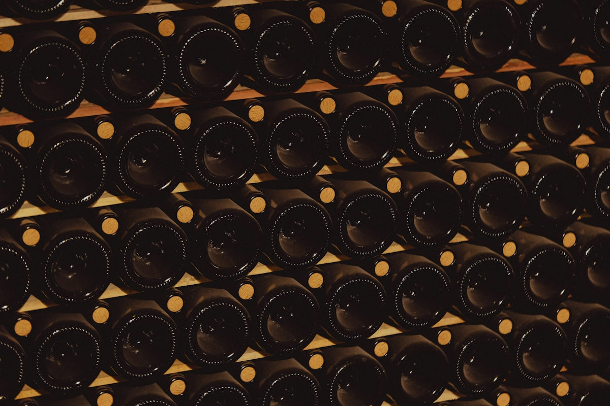 Rows of dark glass wine bottles stacked on shelves