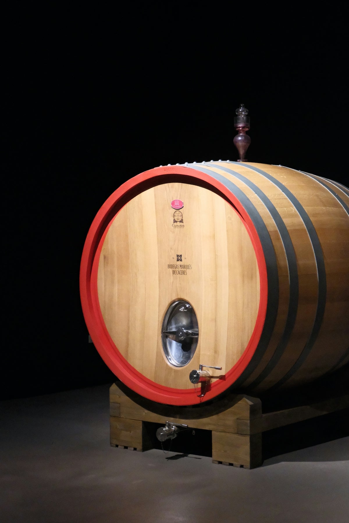 A wooden wine barrel with red accents on the ends
